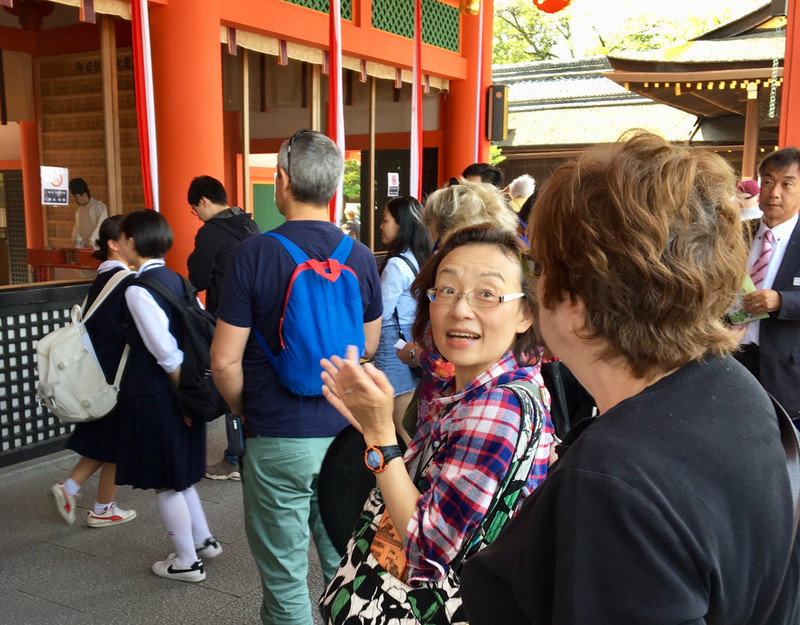 guide Hori explains ritual at Fushimi Inari shrine