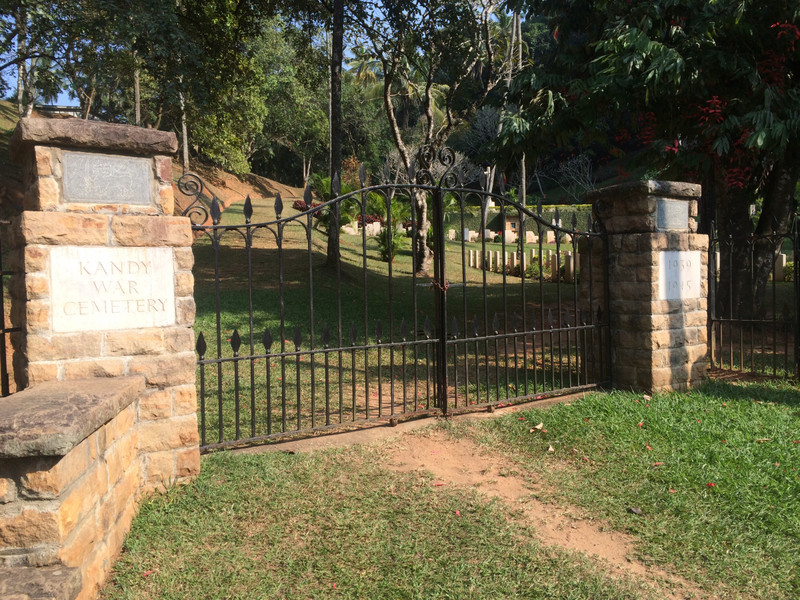 Kandy War Memorial Cross just visible through closed cemetery gates