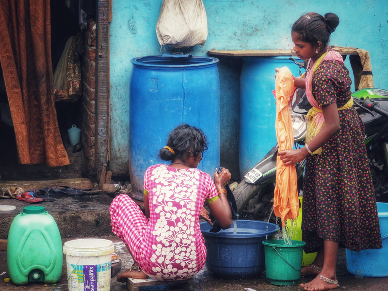 Women doing laundry in buckets in the street, Mahim East