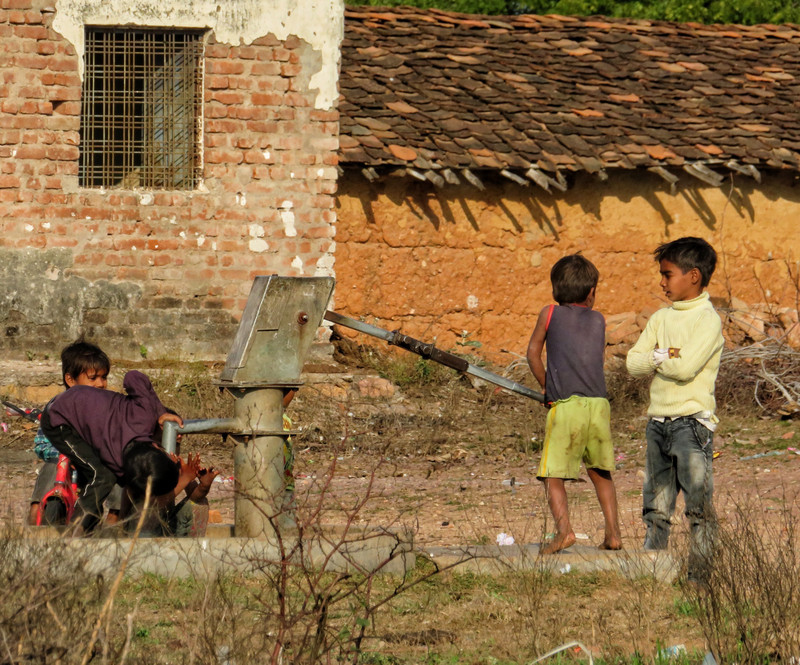 Kids using water pump at the school