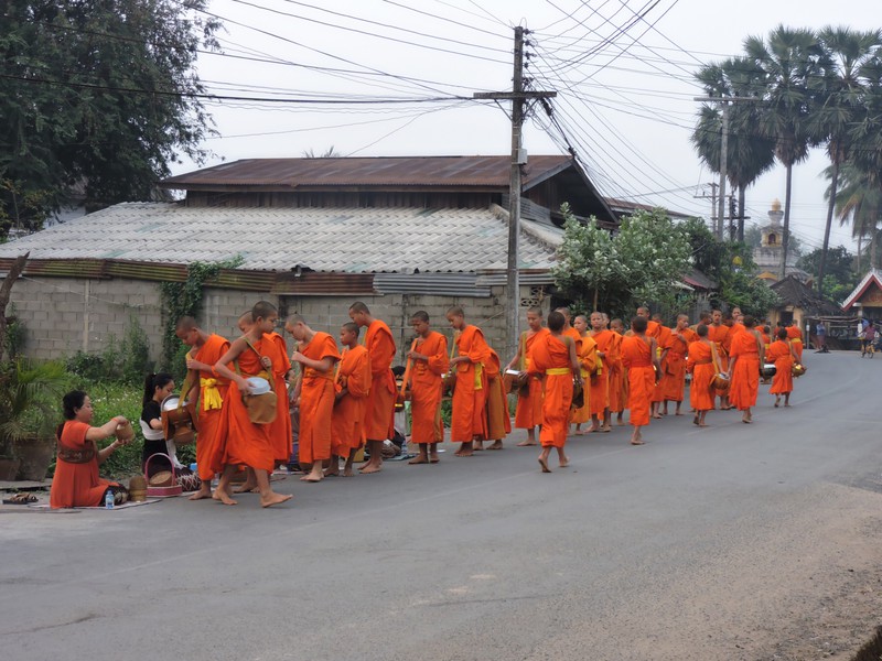 Monks receiving alms outside the guesthouse.