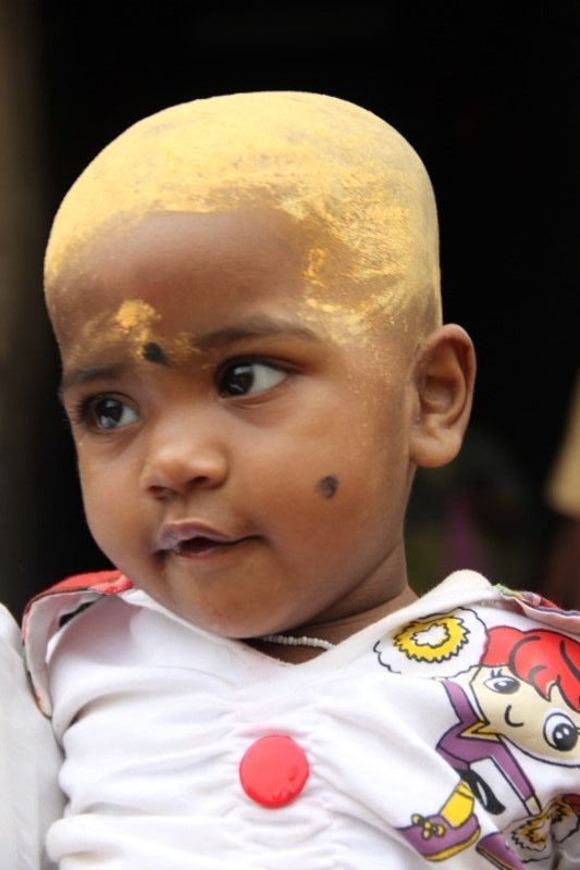 Boy with head shaved out of respect for Lord Shiva