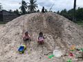 Local kids playing on what looked like cement. It was sand for building.