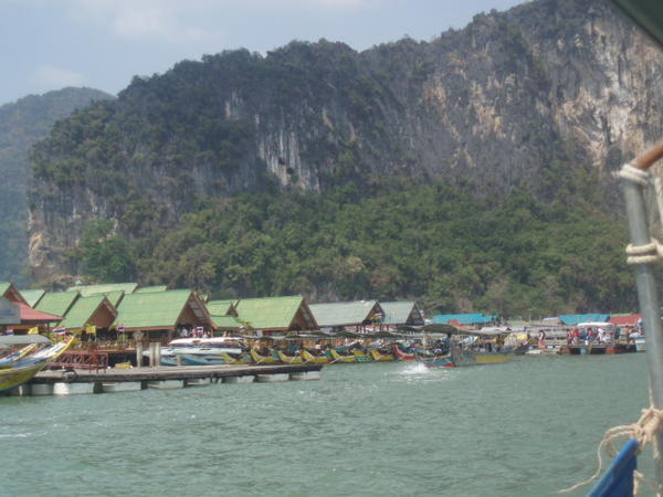 Floating village with many long tail boats.