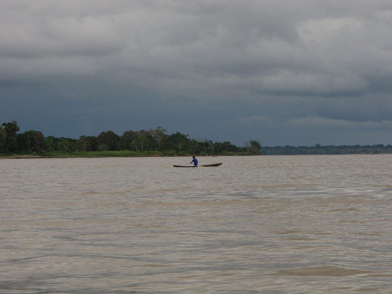 Hard work rowing a dugout canoe across the Amazon