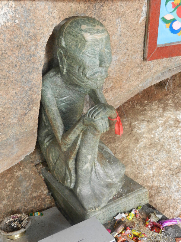 Statue of a hermit with offerings