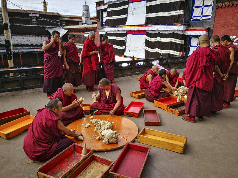 Monks working on sampa, barley meel 