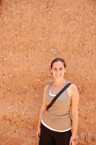 Laure in front of a mud wall/pise