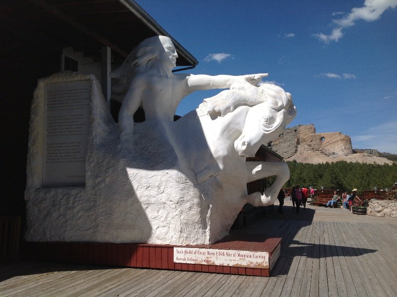 Sculpture of Crazy Horse with progress of mountain sculpture in background