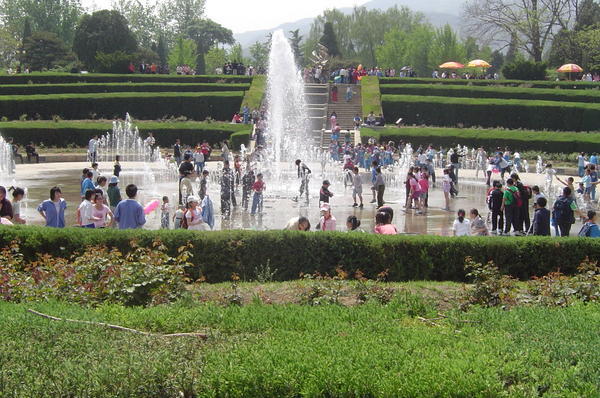 Schoolchildren playing in the fountains on a hot day 
