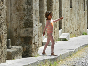 Little Greek girl dancing in the street