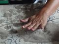 Pressing the sand onto the design