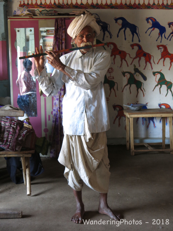 Local village farmer playing the flute