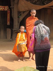Buddhist Monks receiving alms in a small rural village - Cambodia