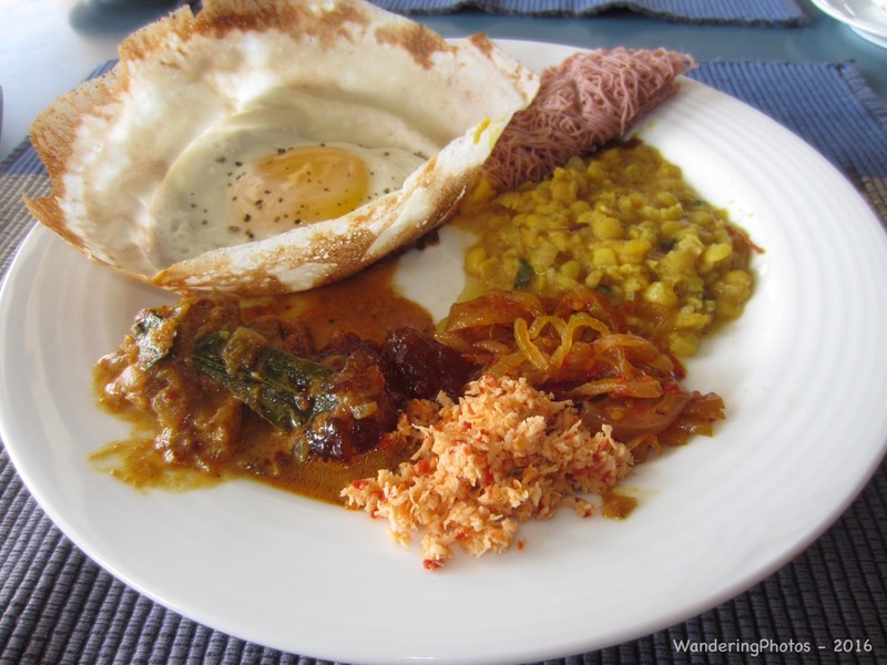 Sri Lankan breakfast curry - Egg hopper, red string hopper, Chicken curry, Dhal curry, coconut sambol, tempered onion & mango chutney. 