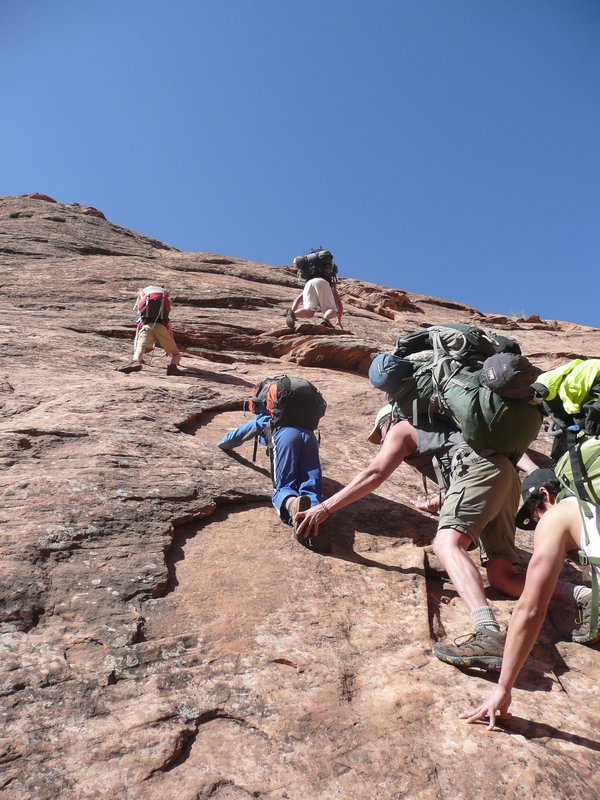 Climbing up a rock face on the Coyote Gulch trail.