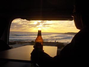 Siobhan sipping a beer while looking out a sunset in WA