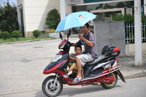 father-son moped ride sunny day