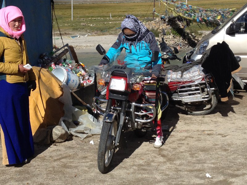 Two Tibetan Girls Attempting to Ride A Motorcycle 