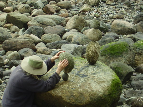 Guy stacking big rocks on small ones