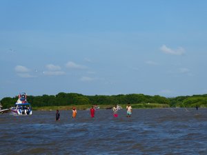 Local men coming out to push our boat off the sandbar