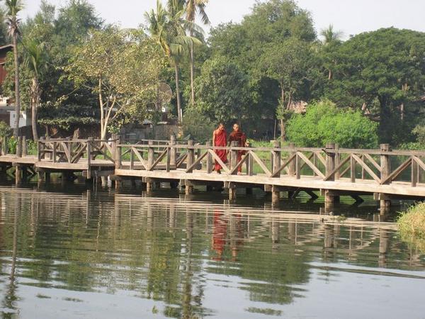 Monks walking across the bridge in Mandalay