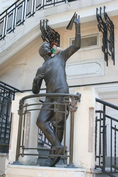 Statue of a man throwing a paper plane