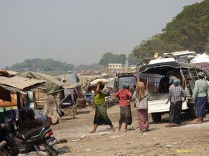 Ladies unloading a truck and carrying sacks to a boat
