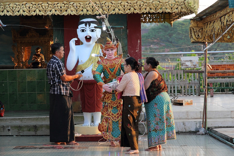 Donating to the temple guardian, Kyaikthanlan Pagoda