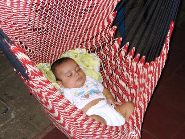 baby sleeping in a hammock at the market