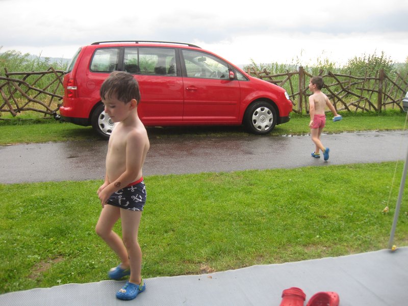 boys get onto car washing in the rain