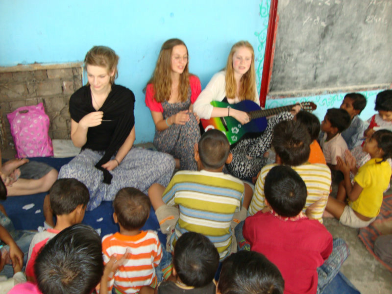 female volunteers playing with children