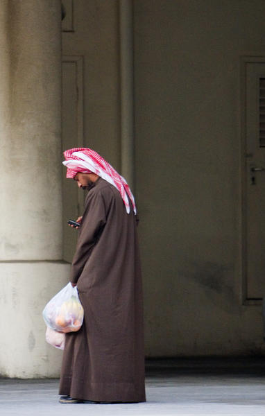 muslim man checks his cell phone
