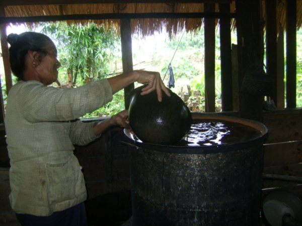 Old lady in the village uses an old war helmet to stir the whisky!