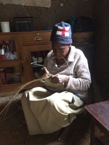 The mother of one of our beneficiaries teaching us how to weave baskets