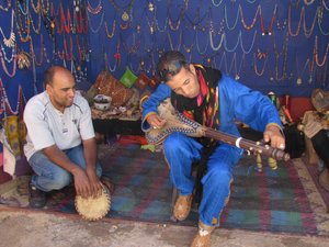 Abdul playing instrument at small shop in Todra Gorge