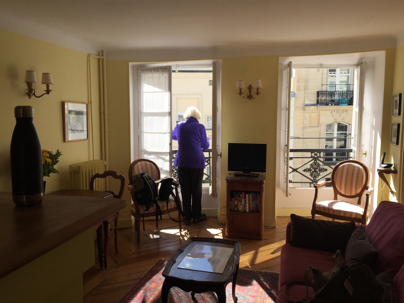 Mom looking out the window of our Paris apartment