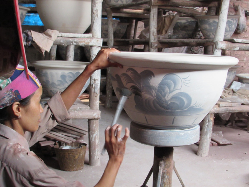 Woman decorating pot at ceramics studio