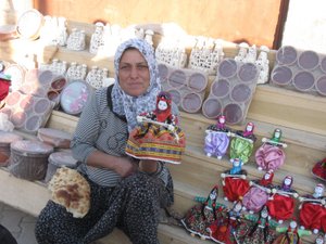 Village woman selling dolls outside the underground city entrance