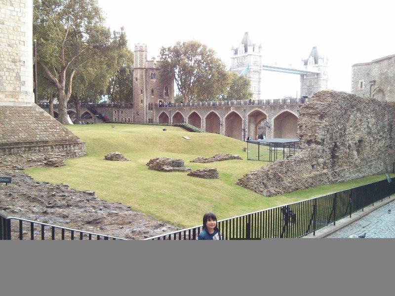 Part of The Tower of London with Tower Bridge in the background.