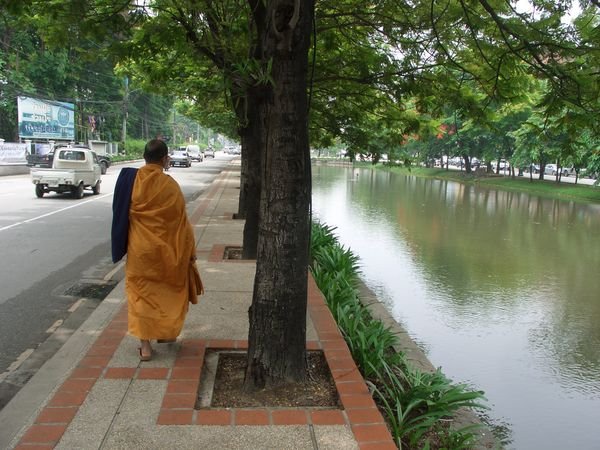 MONK WALKING BY THE MOAT