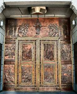 The main door, clad in copper, is adorned with tooled images of scriptural scenes.