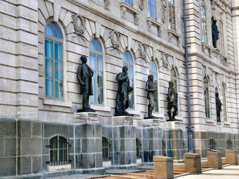 Provincial heroes line niches in the National Assembly facade.