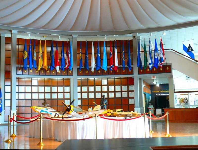The rotunda has a circular table with small models, plus numerous tributes, paintings sculptures, and flags.
