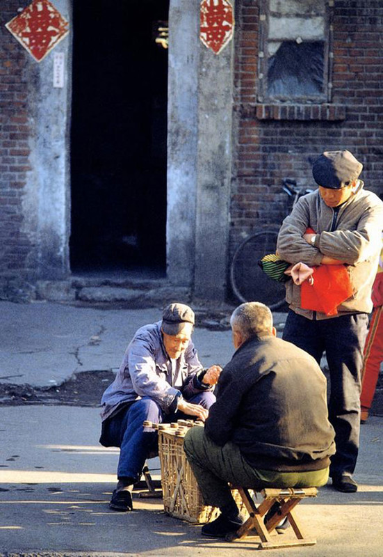 Deux vieux Pékinois jouant aux cartes au coeur d'un hutong