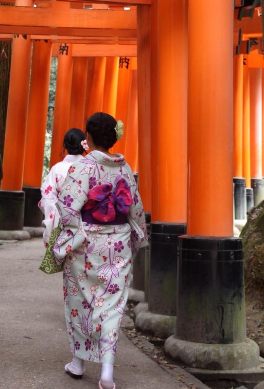 Women in kimono walk the Tori