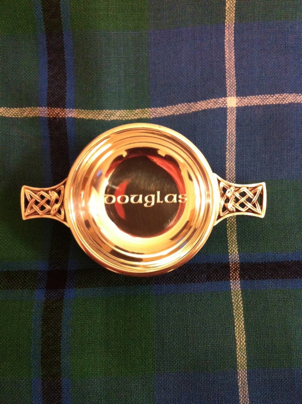 Quaich = Scotch drinking vessel. Engraved in a celtic font: Douglas. Background is the Douglas tartan plaid.