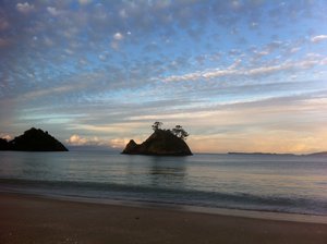 Reflet du soleil couchant à l'horizon de Whangapoua beach