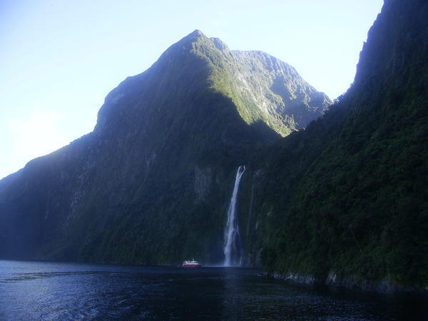 Boat dwarfed by waterfall
