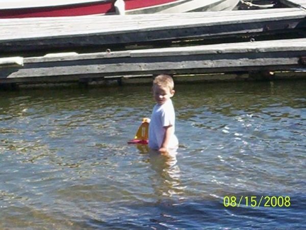 Braeden in the water with his boat